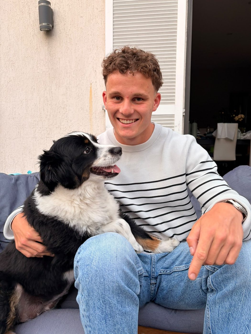Thomas Lairy, souriant, avec un border collie dans les bras